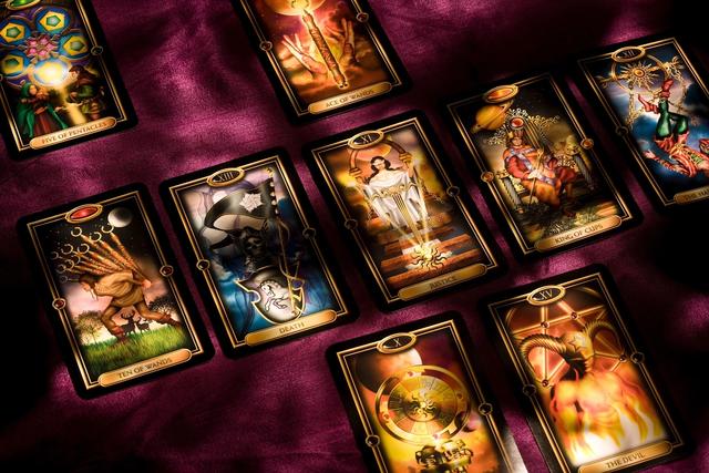 A Celtic Cross layout of tarot cards on purple fabric